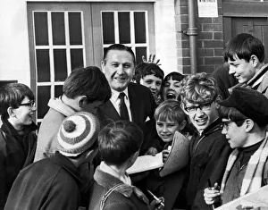 Former Blackpool footballer and current manager Stanley Mortensen surrounded by young