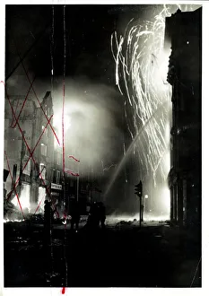 Blazing debris descending on firemen as they play on the burning buildings in London