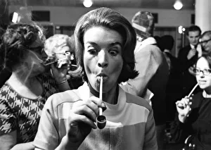 Blonde 28-year-old Jane Lumby experiments with her first pipe smoke at the Festival Hall