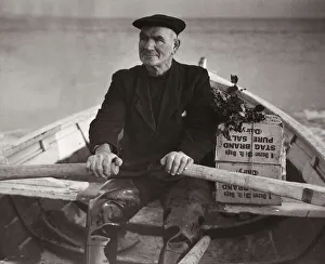 Boatman Old Alick rows the holly toped boxes of Christmas gifts from the families ashore