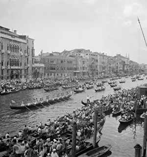 Gondolier Prints: Boats and gondolas tied up as the procession of gondolas pass along the Grand Canal