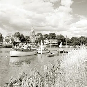 Relaxation Prints: Boats sailing along a river while long grass grows on the bank beside Circa 1955