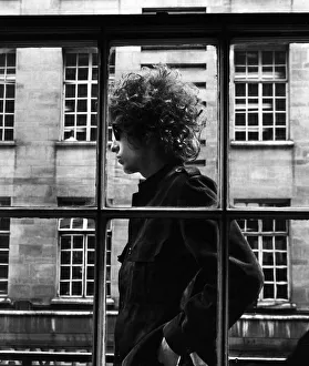 The one and only Bob Dylan pictured walking past a shop window in London, 3rd May 1966