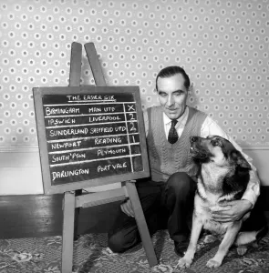 Alsatian Prints: Bob Smith and his alsatian dog who helps him pick his football pools. 1957