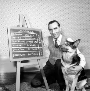 Bob Smith and his alsatian dog who helps him pick his football pools. 1957