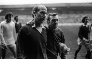 Dejection Prints: Bobby Charlton gets a pat on back from Leeds trainer after Leeds had beaten Manchester