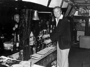 Public Houses Prints: Bobby Moore ex footballer serving drink behind bar The Three Horseshoes