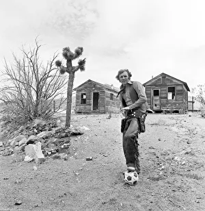 00400 Prints: Bobby Moore poses for the camera dressed as Cowboy when the West Ham team were on a close