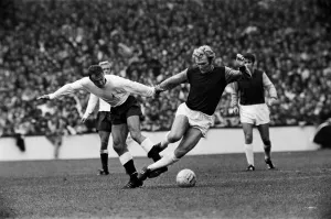 Bobby Moore of West Ham is tripped by Tottenham Hotspur forward Jimmy Greaves during
