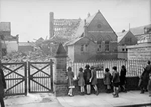 Bombing Collection: Bomb damage at Saltburn, children looking at a bombed building from a metal fence