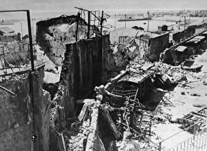 Bomb wrecked warehouses and freight wagons on the quayside at Catania