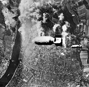 Two bombs drop from a US heavy bomber towards U-boat yards in the German district of