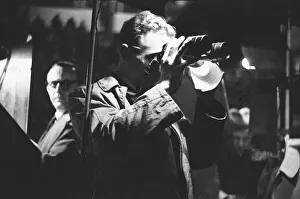 Binoculars Prints: One of the bookies at the White City Greyhound Track keeps an eye on the action