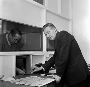 A bookmaker accepting a bet from a punter at Eric Barbers betting shop in Old Trafford
