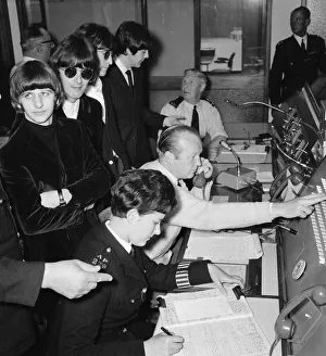 A bored looking Ringo Starr listens as the Beatles are shown around the new police