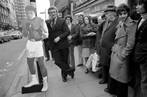 Boxer Joe Bugner waiting at a bus stop with a life size cut out of Mohammad Ali on his
