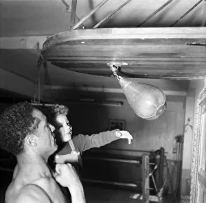 00021 Prints: Boxing. Boxer Alex Buxton seen here holding his son Punching ball. May 1953 D2547