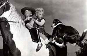 Boy and girl on horse as dog jumps on - October 1953 David Sutton dressed as cowboy