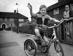 Shorts Prints: A boy plays on his tricycle on a council estate as his mother looks on 1955