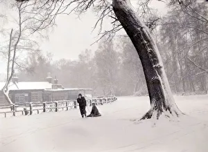 Sleighs Prints: Boys playing the snow near their home. One child pulls his friend along on a home made