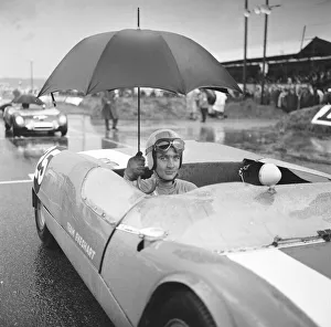 Racing Car Prints: Brian Hart holds an umbrella up to keep off the heavy rain as he waits for the start of