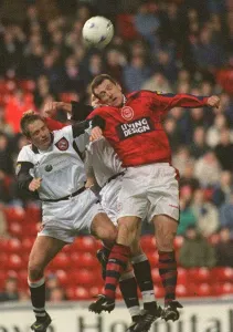 Brian Irvine Aberdeen football player challenges Dundee United players for the ball