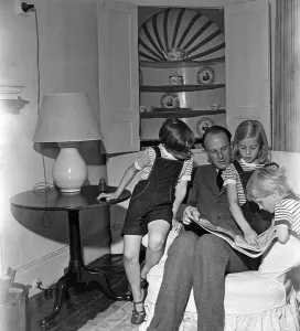 1949 Prints: Brigadier Fitzroy Maclean looking through a copy of Life with his children Jeremy
