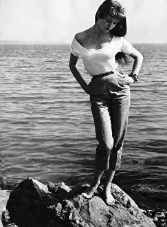 Core200 Prints: Brigitte Bardot French actress standing on rocks on sea shoreline, Cannes Film Festival