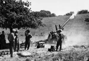 A British 5. 5 gun shelling the enemy over wooded slopes near Vallee, on the road Falaise