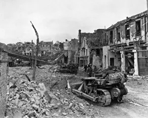 Clearing Prints: British advance in Normandy. Bulldozers clearing debris after entering Faubourg de