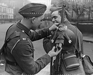 01445 Prints: British Army, a fellow soldier adjust the lady doll to his comrades gun