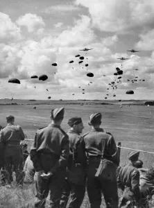 Paratroops Prints: British army soldiers watch paratroops descending from aircraft during a demonstration in