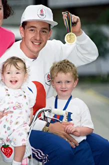 Medals Prints: British cyclist Chris Boardman poses with his family on arrival at Manchester airport as