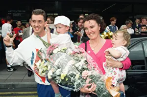British cyclist Chris Boardman poses with his family on arrival at Manchester airport as