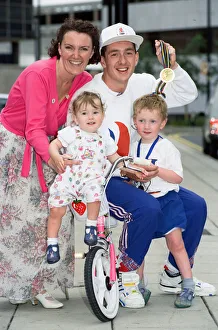 British cyclist Chris Boardman poses with his family on arrival at Manchester airport as