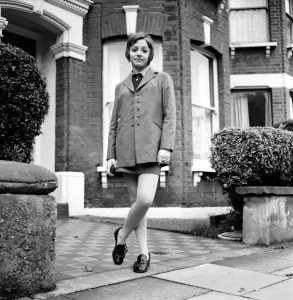 British family feature: Young teenage girl wearing school uniform walking down the street