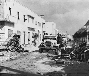 British infantry pass a wrecked transport as they enter Benghazi during Second World War