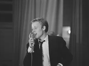 British pop singer Mike Sarne performing on stage with his band