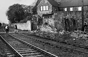 A British Rail workman escorts a pedestrian across the line after a wall crashes down