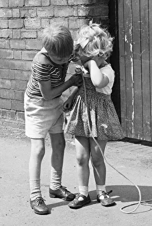 01329 Prints: A brother comforts his sister during the long summer school holidays as she has no one to
