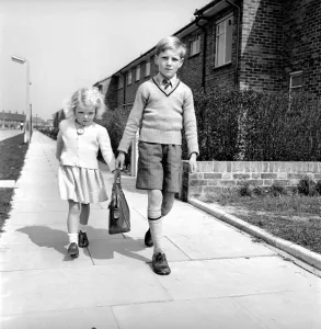 00092 Prints: Brother and sister carry the shopping bag after running errands for mother. 1954 A228c