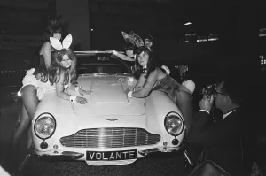 Bunny Girls drapped over an Aston Martin Volante car at the British International Motor