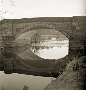 Landscape Features Prints: The Burn is tranquil as it passes underneathe the bridge in the fading sunlight not far