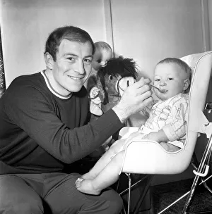 00440 Prints: Burnley football player Ralph Coates feeds his new baby girl Lisa. December 1969
