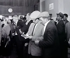 A busy scene inside a betting shop with punters queuing to make bets minutes before