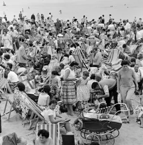 A busy scene on the seafront at Margate, Kent with holidaymakers packing the beach during