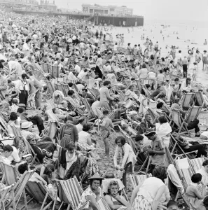 A busy scene on the seafront at Margate, Kent with holidaymakers packing the beach during
