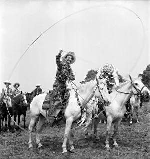 Native American Prints: Cal McAndrew on horseback with a lasso seen alongisde - Carol Gray dressed as a Indian