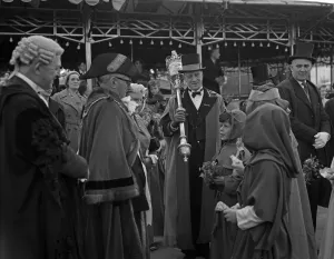 Cambridge mayor Leonard D. V. Wordingham presents a small bag of pennies to two children