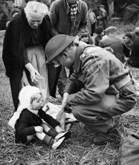 01452 Prints: Canadian soldiers tend to French Refugees in Normandy shortly after the successful